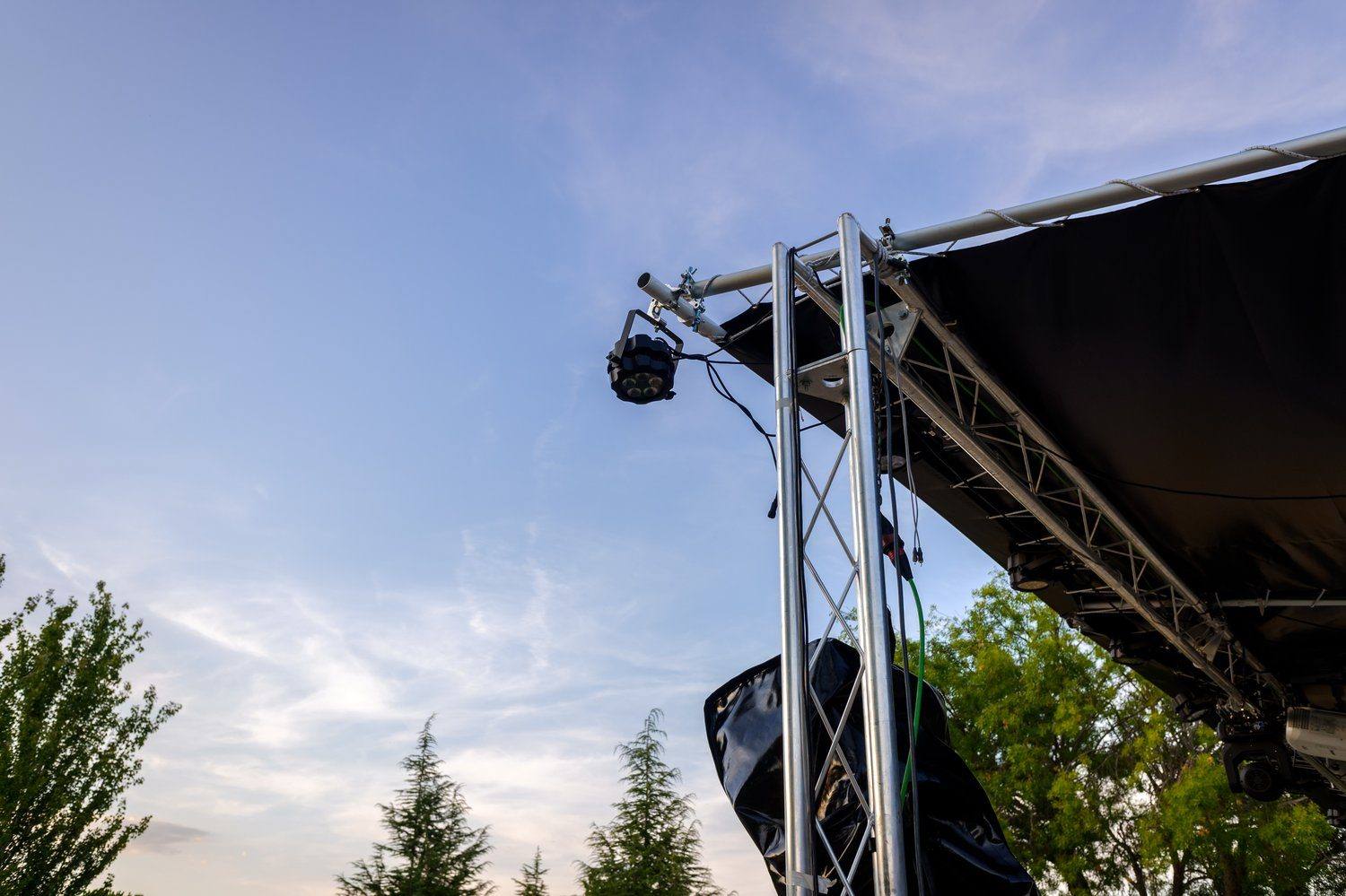 Ekipa techniczna montująca konstrukcję sceny koncertowej w świetle dnia