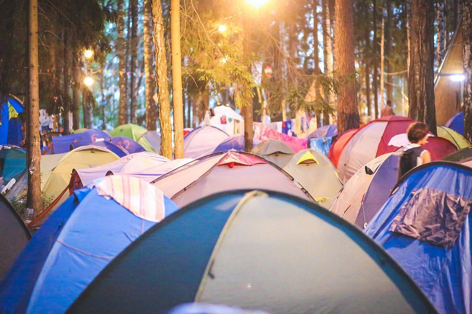 Namioty na polu festiwalowym o zmierzchu w ciepłym świetle